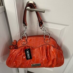 NWT xoxo orange handbag. Prim and proper style. Inside zippered pocket.